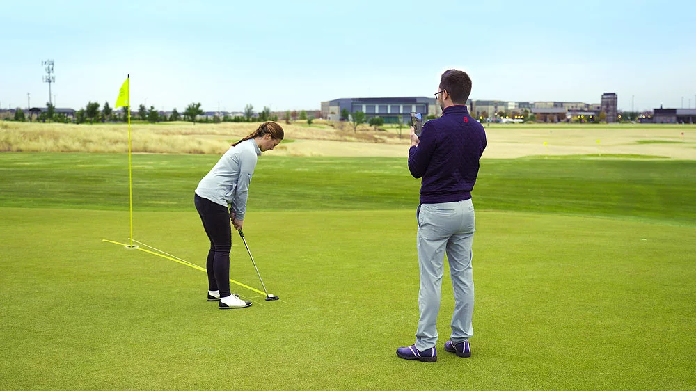 A PuttView coach giving a putting lesson on a golf course green